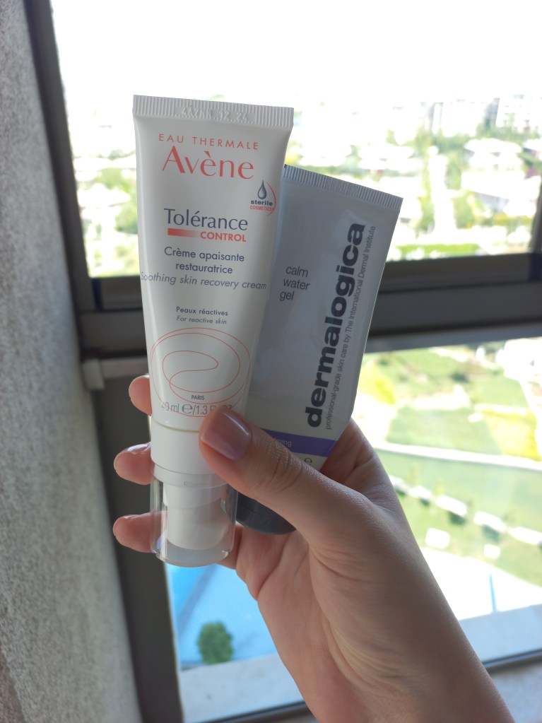 A hand holding skincare products